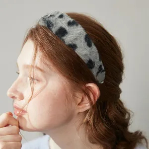 Detail view of a retro fluffy leopard print wide headband, plush winter hair accessory for women.