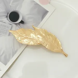 Gold leaf hair clip for women, elegant metallic barrette and chic side hair accessories.