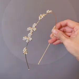 Delicate gold-tone thin headband featuring sparkling rhinestones and elegant pearl butterfly details.