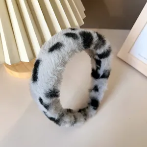 Detail shot of a cozy black and white fluffy faux fur headband, perfect for autumn and winter.