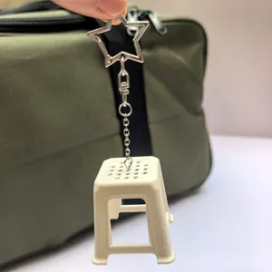 Miniature plastic stool keychain detail view, funny nostalgic novelty bag charm accessory