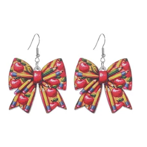 Close-up detail shot of back-to-school pencil and apple print bow earrings for daily wear.