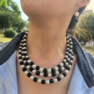 Elegante set di collana multistrato e orecchini abbinati in perle artificiali bianche.