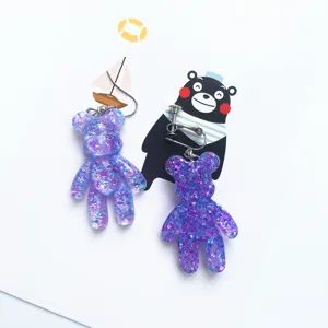 Close-up detail view of purple glitter resin bear earrings featuring cute shiny texture and metal hardware.