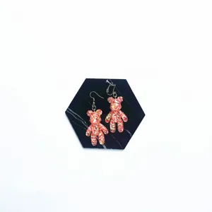 Close-up detail of cute glitter resin bear earrings, sparkly charm for daily wear style.