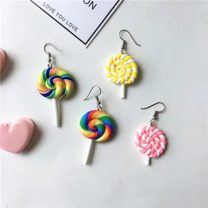 Detailed close-up of colorful polymer clay lollipop earrings, cute and playful handmade sweet style.