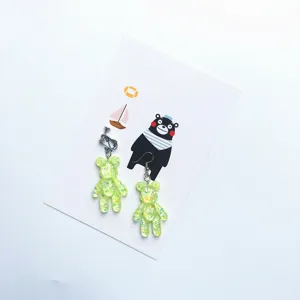 Neon green glitter resin bear earrings, cute asymmetric clip-on and hook design details.