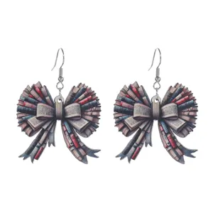 Closeup of creative book bow dangle earrings, unique school style wooden jewelry detail.
