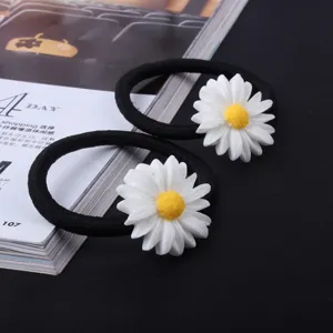 Black elastic hair ties featuring cute white daisy charms, sweet floral hair accessories detail.
