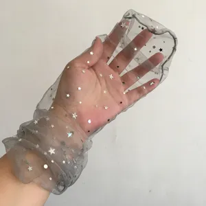 Vista dettagliata del guanto in tulle trasparente con stampa di stelle, accessorio glitterato.