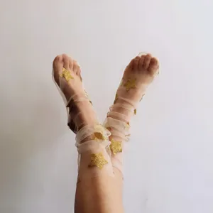 Calze a rete trasparenti con stelle d'oro, collant glitterati per la moda primaverile.