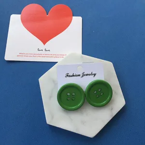 Grüne Knopfohrringe Detailaufnahme, ausgefallener Harajuku Retro Stil Modeschmuck.
