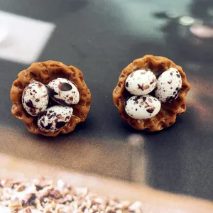 Gros plan de boucles d'oreilles nid d'oiseau oeuf de caille, bijoux fantaisie faits main.