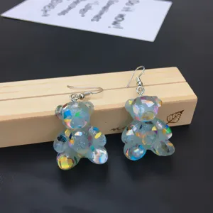 Detail shot of cute handmade glitter bear earrings featuring irregular sequins and hook design.