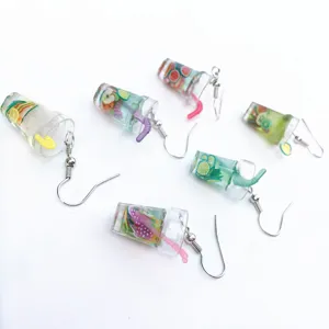 Detailed view of creative miniature fruit tea cup earrings, fun resin drink jewelry.
