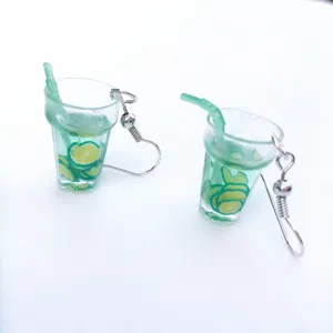 Close-up detail of cute miniature lime juice cup earrings with resin lemon slices and green straw.