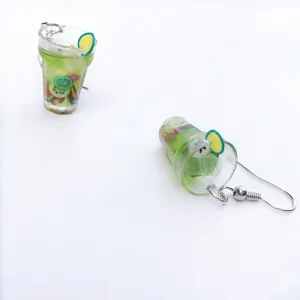 Close-up detail shot of cute resin fruit cocktail cup earrings featuring miniature lemon slices.