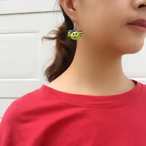 Halloween quirky green spider drop earrings with purple bow, detailed close-up shot of jewelry.