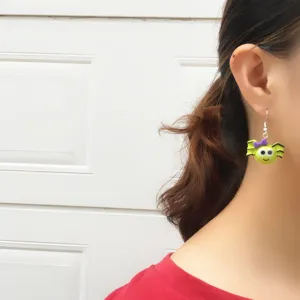 Cute Halloween green cartoon spider earrings with purple bow, funny fashion jewelry.