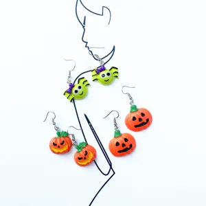 Detailed closeup view of Halloween pumpkin and spider earrings, featuring fun and spooky designs.