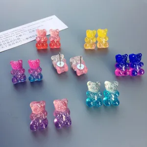 Nahaufnahme von bunten Glitzer-Harz-Gummibärchen-Ohrringen im verspielten Bonbon-Stil.