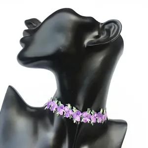 Gros plan d'un collier choker brodé de fleurs violettes, détail de col en dentelle minimaliste.