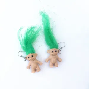 Detail shot of quirky retro Troll doll earrings with bright green hair and metal hooks.