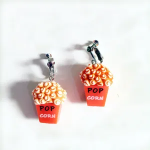 Gros plan de boucles d'oreilles clips seau de pop-corn mignonnes, bijoux en résine.