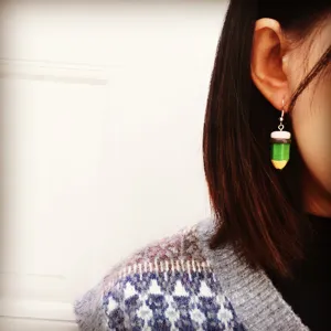 Close-up detail shot of playful handmade pencil dangling earring worn on ear, cute and unique.