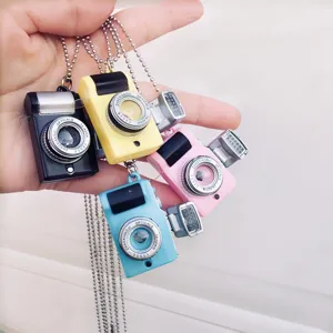 Mini retro camera necklace detail showcasing colorful mini pendants with bead chains and charms.