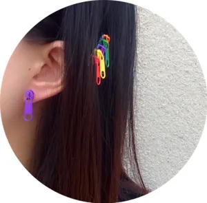 Primer plano detallado de pendientes coloridos de cremallera y pinzas, estilo creativo.