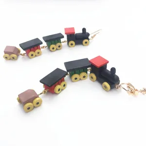 Vue de détail de boucles d'oreilles train en bois créatives, pendantes rétro colorées femme.