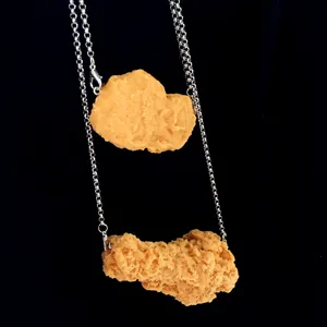 Detailansicht einer lustigen simulierten Hähnchen-Nugget-Halskette, schrilles Modeschmuckstück.