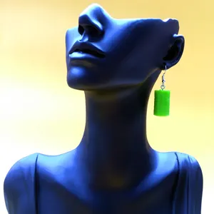 Nahaufnahme Detail der schrägen grünen Ölfass Ohrringe, kreatives handgemachtes Accessoire.