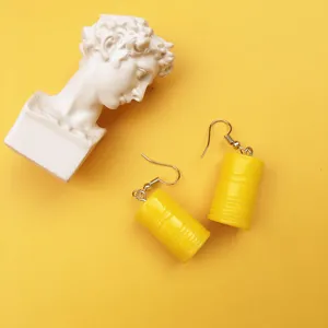 Nahaufnahme Detailaufnahme kreativer gelber Miniatur-Ölfass-Ohrringe mit Kunstskulptur-Requisite.