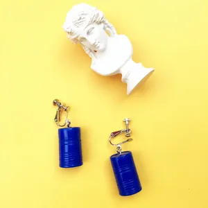 Nahaufnahme kreativer blauer Ölfass-Ohrringe mit Clip-Design, einzigartiger skurriler Stil.