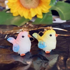 Vue détaillée de boucles d'oreilles oiseau mignon, design animal en résine, bijou tendance.