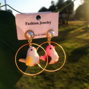 Jolies boucles d'oreilles oiseau dessin animé avec anneau doré et perle fantaisie.
