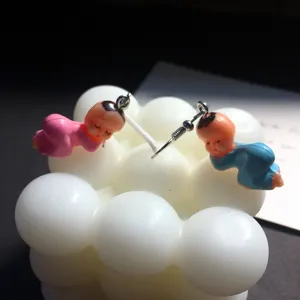 Handgemaakte schattige baby pop oorbellen detailweergave, unieke mini hars figuur decoratie.
