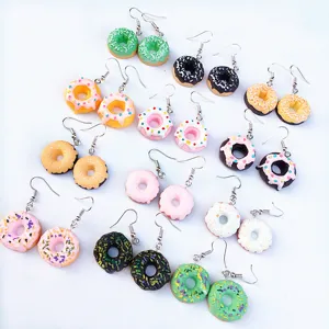 Detailansicht der handgefertigten bunten Harz Donut Ohrringe mit süßem bunten Zuckerguss Design.