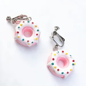Nahaufnahme der süßen handgefertigten Donut Ohrclips mit bunten Streusel und weißem Guss.