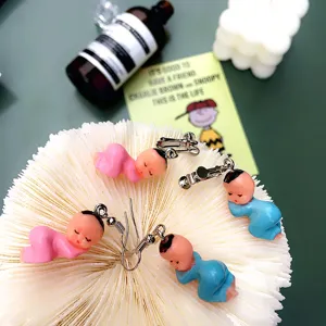 Handgemaakte schattige slapende babypop oorbellen detailopname, unieke hars oorbellen voor dames.