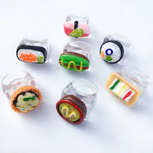 Detail view of cute resin food rings featuring miniature sushi and sandwiches on a clear wide band.