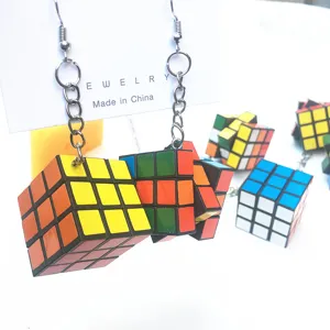 Detailed close-up shot of creative whimsical magic cube dangle earrings, punk trendy jewelry design.