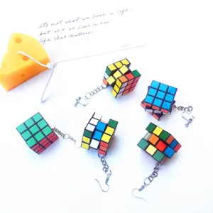 Close-up detail of creative handmade miniature Rubik's cube earrings with metal hooks.