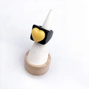 Detail bague coeur geometrique en resine, bijoux style bonbon noir et jaune mignon.