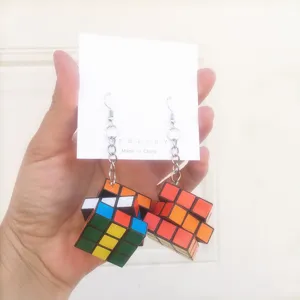 Detail shot of creative Rubik's cube drop earrings with colorful block charms and metal chain.