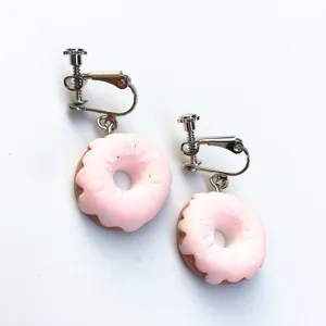 Nahaufnahme der süßen handgemachten rosa Donut Ohrclips mit Glasur und bunten Streuseln.