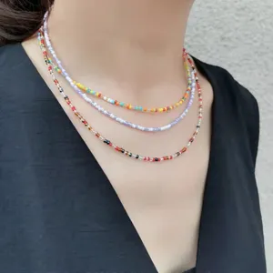 Detailaufnahme mehrlagiger bunter Perlenketten im Bohostil, perfekter Sommerschmuck.