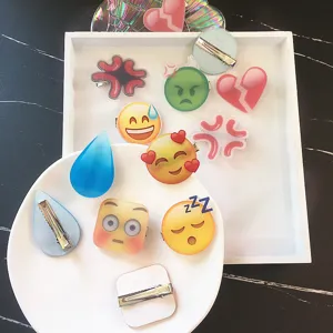 Nahaufnahme von süßen Acryl-Haarspangen mit lustigen Emoji-Motiven und praktischen Clips.